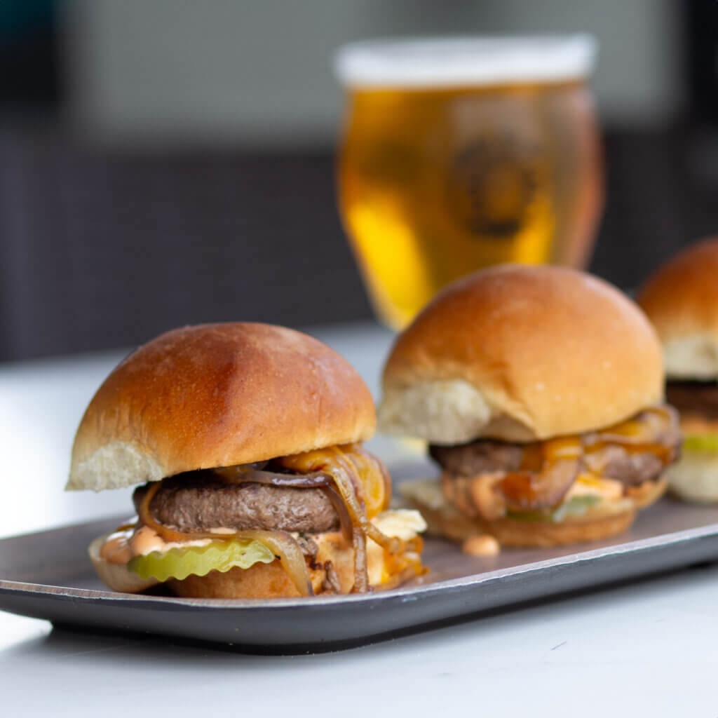 Wanderer Beef Sliders with cheddar, grilled onions, and pickle chips